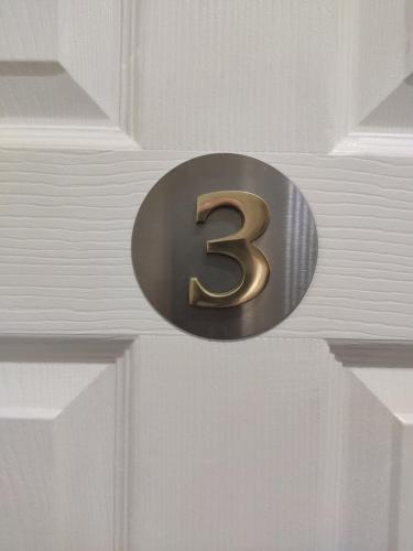 a metal number on a door with a white door at Q Accommodation in Blackpool
