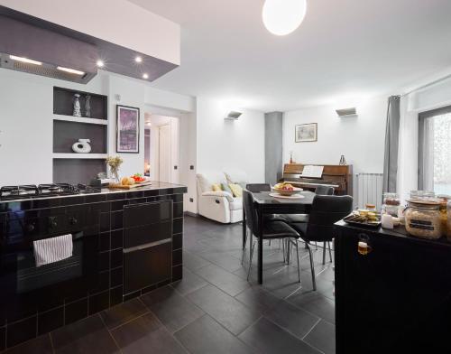 a kitchen with black appliances and a living room at The Peaceful Apartament Close to Milan in Trezzano sul Naviglio