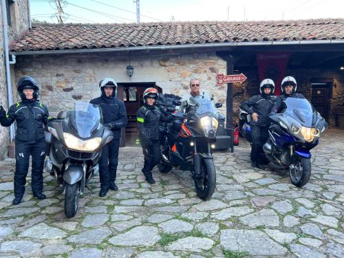 a group of people standing next to their motorcycles at Hotel Moto-Rural "VEGALION" in Las Salas