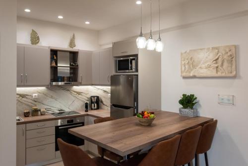 a kitchen with a wooden table and some chairs at Blue Ark Acropolis Compass in Athens