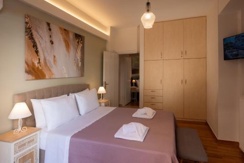 sypialnia z dużym łóżkiem z dwoma ręcznikami w obiekcie Blue Ark Acropolis Compass w Atenach