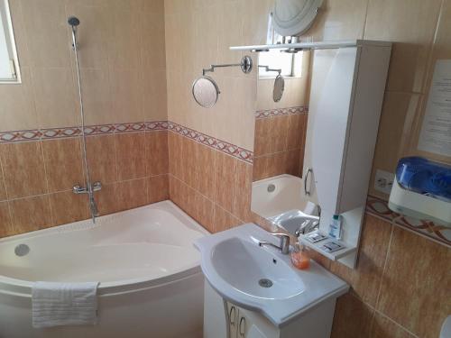 uma casa de banho com uma banheira, um WC e um lavatório. em Pensiunea Crown Royal em Alba Iulia