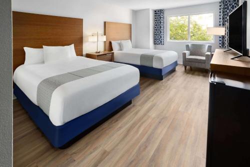 a hotel room with two beds and a television at WaterView Casino & Hotel, Trademark Collection by Wyndham in Vicksburg