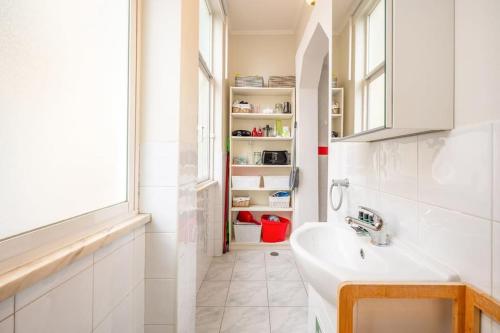 ein weißes Bad mit einem Waschbecken und einem Fenster in der Unterkunft GuestReady - Spring break in Lisbon in Lissabon