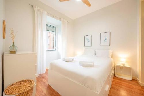 ein weißes Schlafzimmer mit einem weißen Bett und einem Fenster in der Unterkunft GuestReady - Spring break in Lisbon in Lissabon