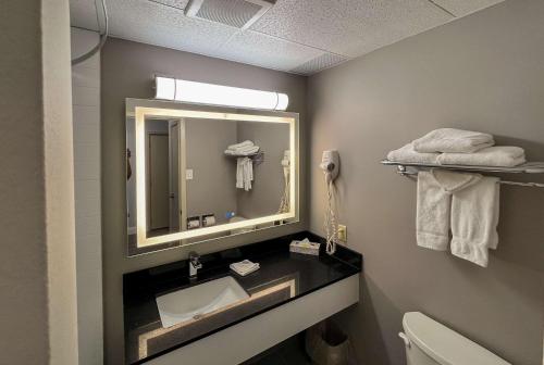y baño con lavabo y espejo. en Motel 6 Sault Ste. Marie, ON en Sault Ste. Marie