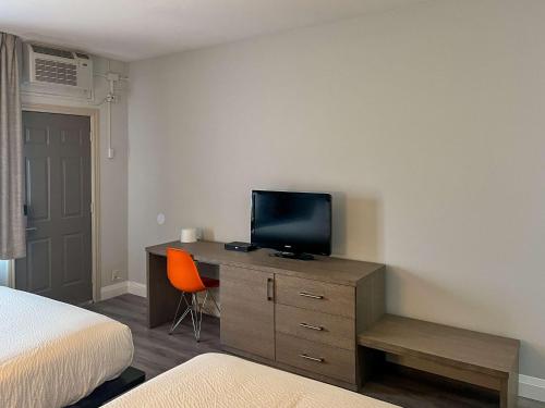 a bedroom with a bed and a television on a dresser at Motel 6 Sault Ste. Marie, ON in Sault Ste. Marie