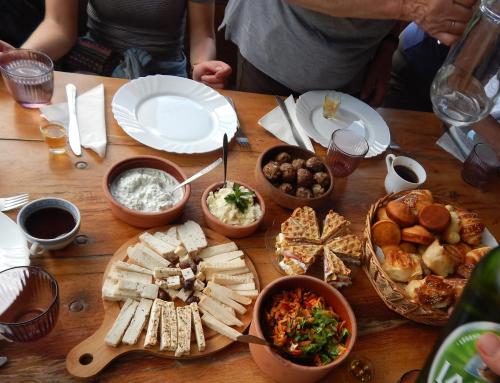 uma mesa de madeira coberta com pratos e tigelas de comida em Dome Home Tents Taor em Valjevo