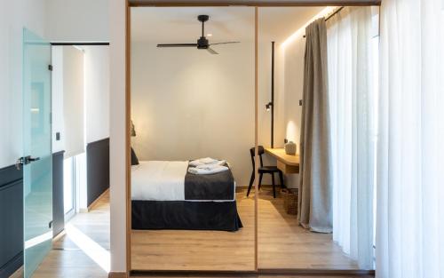 Nostos - Luxury Apartment in Agrinio في أغرينيو: غرفة نوم بسرير ومرآة