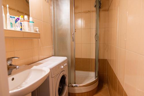 y baño con ducha y lavadora. en Private room 1 km from center with kitchen en Bratislava