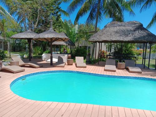 einen Pool mit Stühlen und Sonnenschirmen in der Unterkunft Le Choisy Mauritius in Mont Choisy