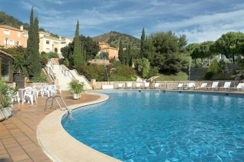 a large swimming pool with chairs and a building at Four Bedroom Atalayas Ii Villa - La Manga Club in Atamaría