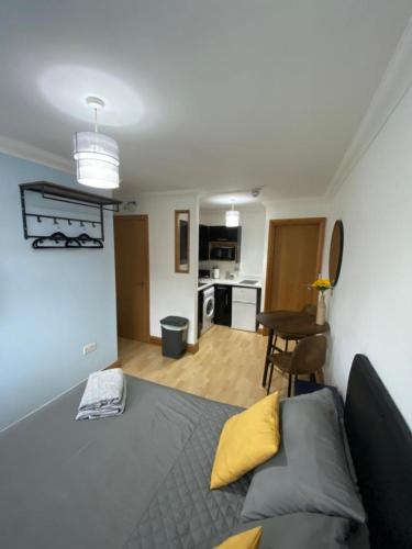 a bedroom with a bed and a kitchen with a table at Studio apartment in Norwich City centre in Norwich