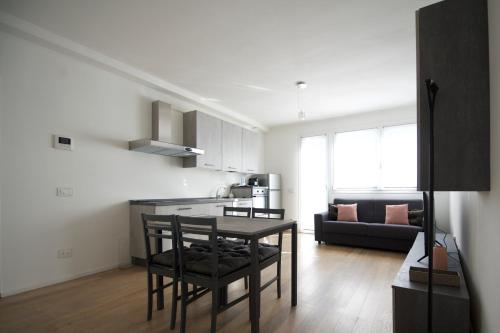 a kitchen and living room with a table and a couch at Suite Art Padova Centro in Padova