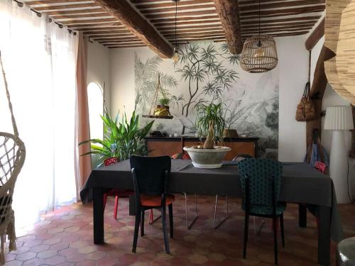 uma sala de jantar com uma mesa preta e cadeiras em Maison de village avec 2 jardins em Pernes-les-Fontaines