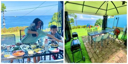 a woman and a child sitting at a table with food at 露天風呂オーシャンビューBlue Ocean IZU in Ajiro