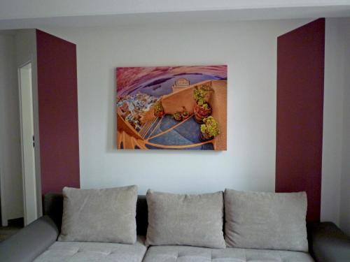 a living room with a couch and a painting on the wall at Ferienwohnungen und Ferienhäuser Gohr in Stralsund