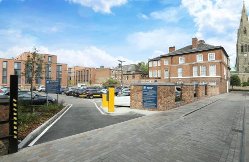 a city street with cars parked in a parking lot at St Martins Lodge in Leicester