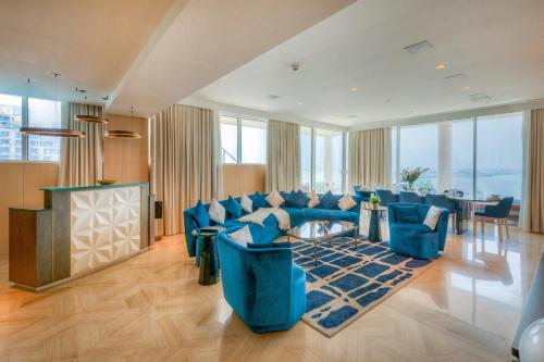 a living room with a blue couch and a table at EDEN'S Homes & Villas - FIVE Palm Residences Penthouses in Dubai