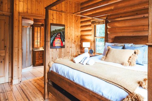 1 dormitorio con 1 cama en una cabaña de madera en Chalet Authentik 50 - Hot tub, Pools, Lake & Resort, en Mille-Isles