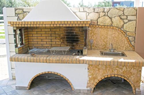 eine Außenküche mit einer Spüle und einer Steinmauer in der Unterkunft Villa Campos- Less than 5-Min Walk to Kalivaki Beach in Georgioupoli