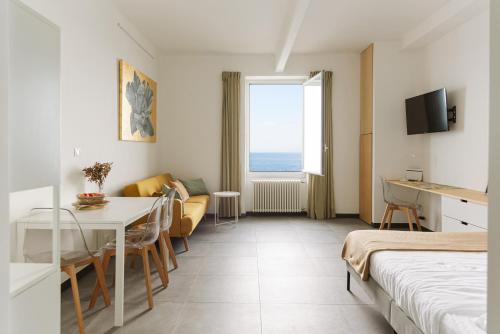 a hotel room with a bed and a dining room at Cà de Mâ - Sea Front Suite in Genoa