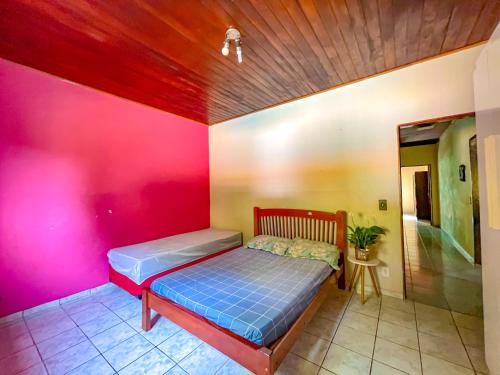 a bedroom with a bed and a pink wall at Espaço Céu Azul in Nazaré Paulista