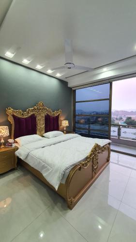 a bedroom with a large bed and a large window at Citi Hotel Apartments in Jhelum