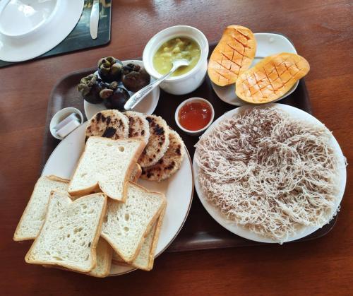 a tray of breakfast food with toast and bread at Coco Bay in Beruwala
