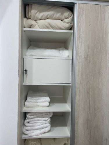 un placard avec des serviettes blanches assises sur des étagères dans l'établissement AIKA Monoambientes, à Salta