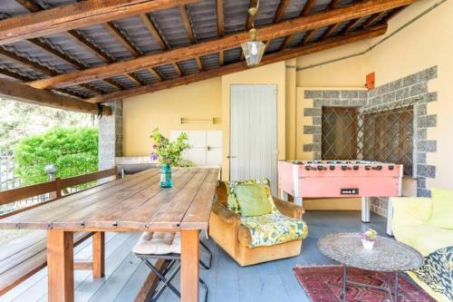 een patio met een houten tafel en een pooltafel bij B&BTorre Cives in Vidracco