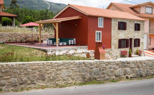 a house with a stone wall and a patio at Casa Menora Playa de Carnota in Carnota