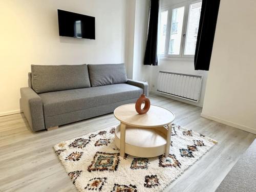 un salon avec un canapé et une table dans l'établissement Stade de France 8min - Idéal JO 2024, à Saint-Denis