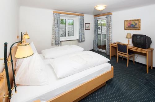 安尼夫的住宿－謝斯林旅館，一间卧室配有一张床、一张书桌和一台电视