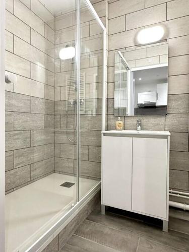 une salle de bain avec une douche, un lavabo et un miroir dans l'établissement Stade de France 8min - Idéal JO 2024, à Saint-Denis