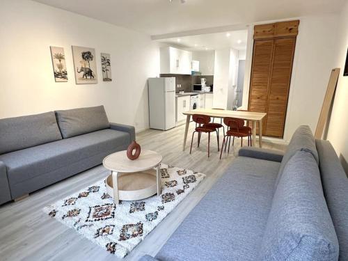 un salon avec un canapé et une table dans l'établissement Stade de France 8min - Idéal JO 2024, à Saint-Denis