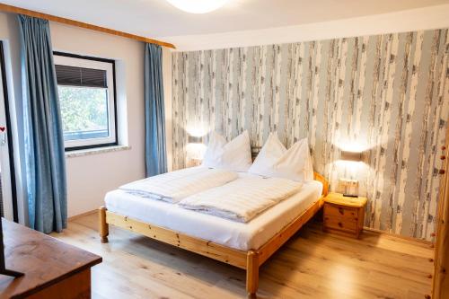 sypialnia z łóżkiem z białą pościelą i oknem w obiekcie apartHAUS w mieście Haus im Ennstal