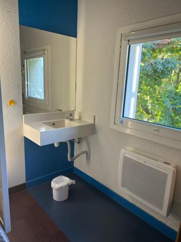 une salle de bain avec un lavabo et une fenêtre dans l'établissement Fyl hôtel Saint Pol, à Cité Égalité