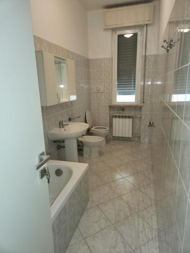 uma casa de banho com um lavatório, uma banheira e um WC. em NIKI HOME em Podenzano