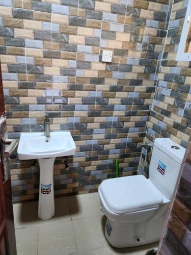 łazienka z toaletą i umywalką w obiekcie See Good Guest House Enimarire w mieście Sangotedo