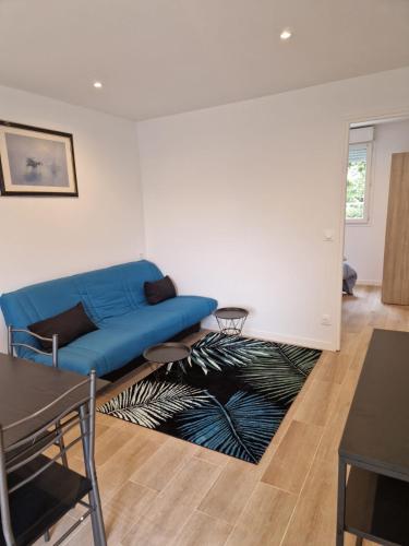 un salon avec un canapé bleu et un tapis dans l'établissement Spacieux et lumineux Appartement, à Aulnay-sous-Bois