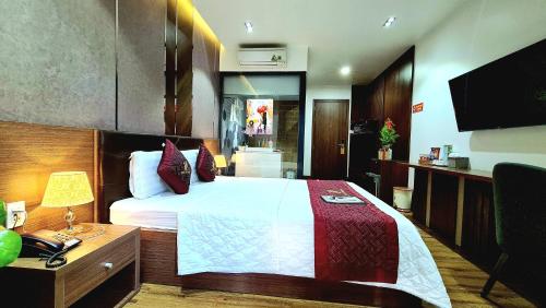 a bedroom with a bed and a desk and a television at THƯ LÊ Hotel in Cao Lãnh