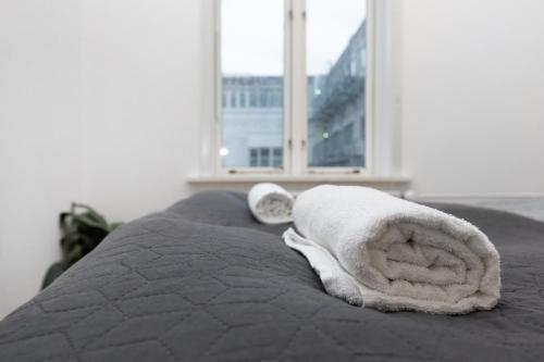 a towel animal laying on a bed with a window at Århus bedst placerede lejlighed & udsigt in Aarhus