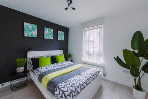a bedroom with a bed with green pillows at SmartSleep Apartments in Glasgow
