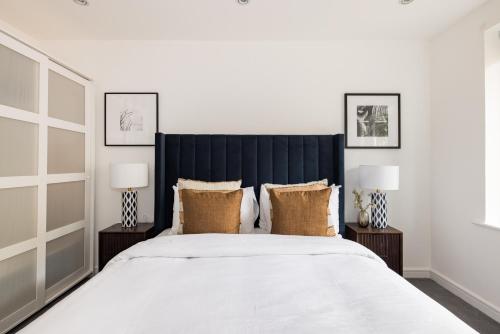 a bedroom with a large bed with two lamps at The Walworth Hideout - Elegant 2BDR Flat in London