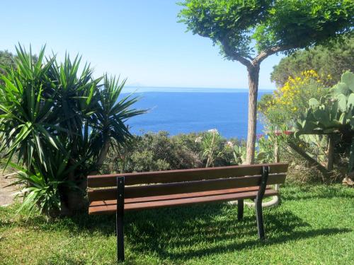 a park bench with the ocean in the background at Apartment Oasis 2 by Interhome in Capoliveri