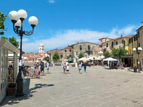 a group of people walking down a street in a town at Apartment Oasis 2 by Interhome in Capoliveri