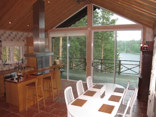 une cuisine avec une table et des chaises ainsi qu'une grande fenêtre dans l'établissement Holiday Home Nedre Gärdsjö - DAN086 by Interhome, à Rättvik