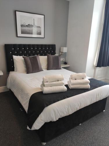 a bedroom with a large bed with towels on it at Q Accommodation in Blackpool