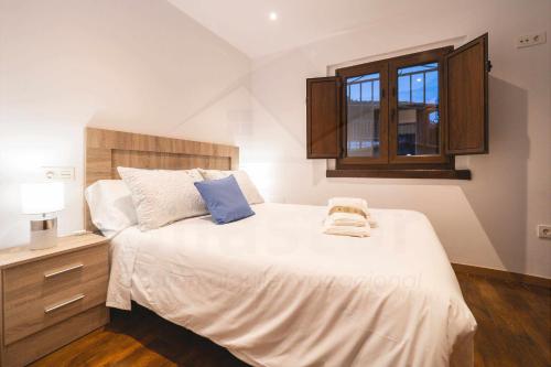 Schlafzimmer mit einem großen weißen Bett und einem Fenster in der Unterkunft Casa Piñera Cudillero 